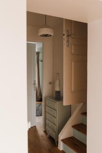 a hallway with a dresser and a door with a mirror at La Maison Gioia in Nerville-la-Forêt