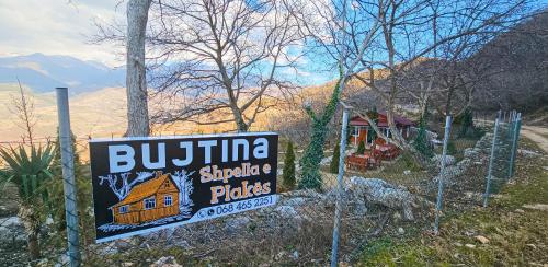 a sign in front of a house with a house at Bujtina Shpella e Plakës Çerçan in Librazhd