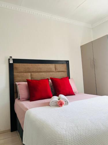 a bedroom with a bed with red and white pillows at Ashridge Guesthouse & Safaris in Hazyview