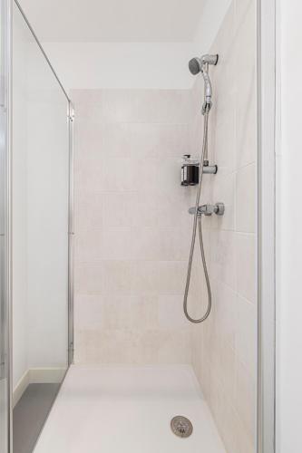 une douche avec pommeau de douche dans une salle de bain dans l'établissement L'Échappée Pyrénéenne, à Pau