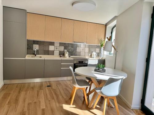 a kitchen with a table and chairs in a room at RIACENTRUM - Smart Residence in Aveiro