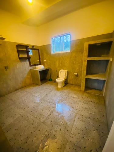an empty bathroom with a toilet and a sink at Southern grace unawatuna in Unawatuna