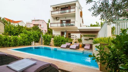 a swimming pool in front of a building at Villa Nia with private pool in Trogir
