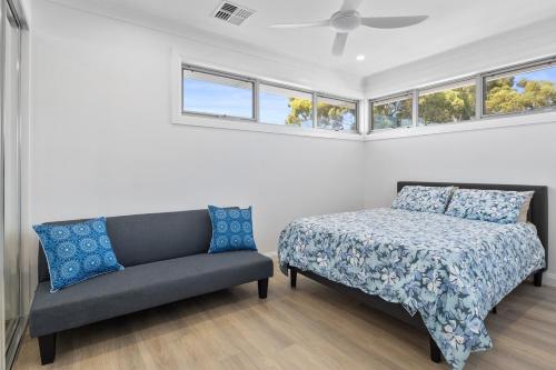 a bedroom with a bed and a couch and windows at Prospect High Street House in Prospect