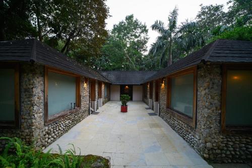 a building with a walkway between two buildings at Sinclairs Retreat Dooars, Chalsa in Chālsa
