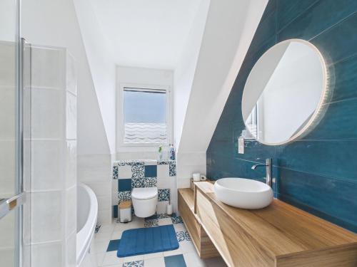 une salle de bain avec un lavabo et un miroir dans l'établissement Maison familiale 7 personnes à 150m de la mer, à Plouguerneau