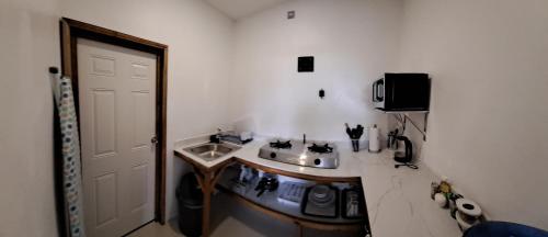 a small kitchen with a sink and a stove at By The Bay Oracabessa Queen Bedroom Suite in Oracabessa