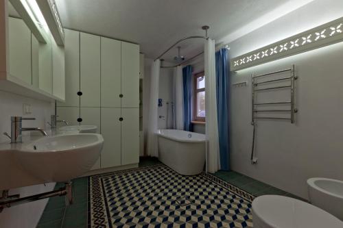a bathroom with two sinks and a tub and a toilet at Vila Balta Balta in Nida