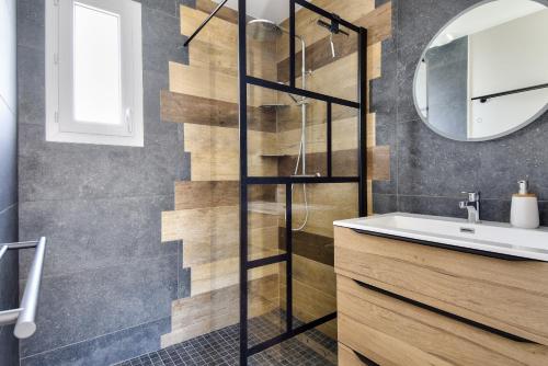 a bathroom with a sink and a mirror at Maison pour 6 - Terrasse - 700 m de la Pointe in LʼHerbaudière