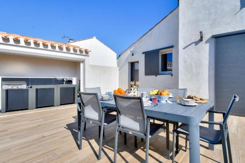 une table et des chaises bleues sur le patio d'une maison dans l'établissement Maison pour 6 - Terrasse - 700 m de la Pointe, à Noirmoutier-en-l'lle