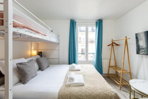 une chambre avec un lit et un lit superposé dans l'établissement Best Deal! Modern studio in vibrant area only 5 minutes by walk to metro - central location, à Paris