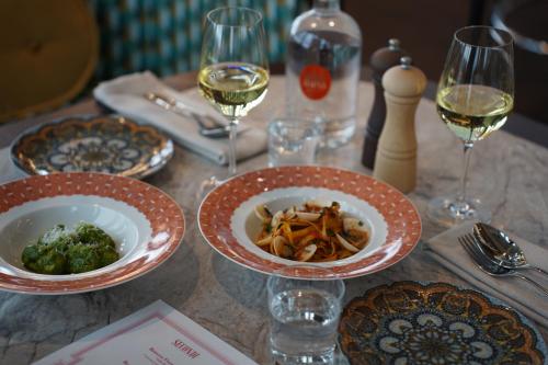 a table with plates of food and glasses of wine at Clarion Hotel Malmö Live in Malmö