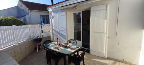 une table et des chaises sur le balcon d'un bâtiment dans l'établissement Maison 3 pièces Oléron 4 couchages La Brée Les Bains LBO000-051, à La Brée-les-Bains