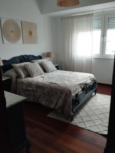 a bedroom with a bed and a window at Mirador urbano sobre el rio in Noya