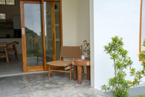 a patio with a table and a chair next to a door at Villa Aura Lombok in Selong Belanak