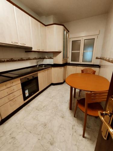 a kitchen with a wooden table and a table and a table and a tablektop at Mirador urbano sobre el rio in Noya