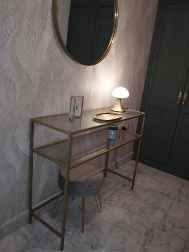 a desk with a lamp and a chair with a mirror at Mirador urbano sobre el rio in Noya