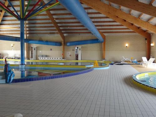 a large indoor swimming pool with several at Kustverhuur, Breskens Zwin 242 in Breskens