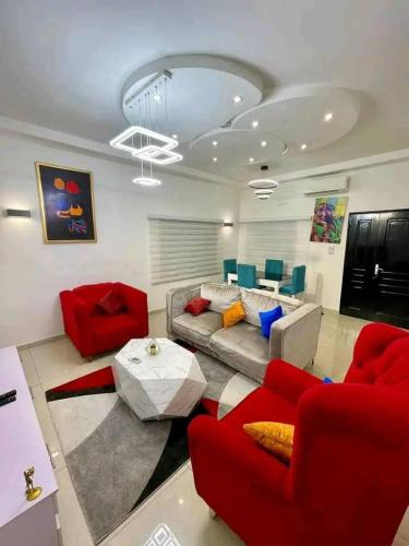 un soggiorno con sedie rosse e un divano di Villa pacha a Cotonou