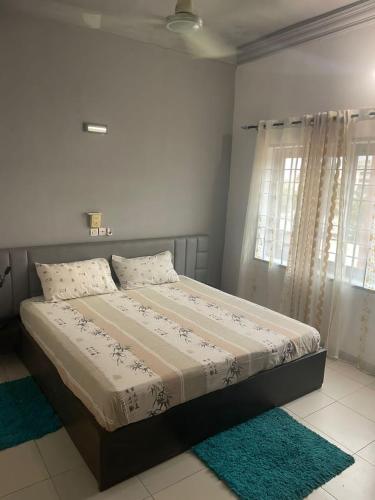 una camera da letto con un letto grande con due finestre di Villa pacha a Cotonou