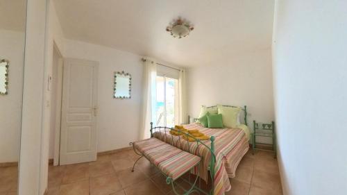 a bedroom with a bed with a bench and a window at Fantastic Large Villa with Garden, Pool and Jacuzzi in Néffiès