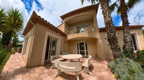 a house with a patio with a table and chairs at Fantastic Large Villa with Garden, Pool and Jacuzzi in Néffiès