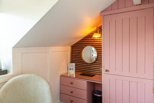 a room with a vanity with a mirror and a chair at Holly Lodge Guest House with FREE off site health club in Windermere