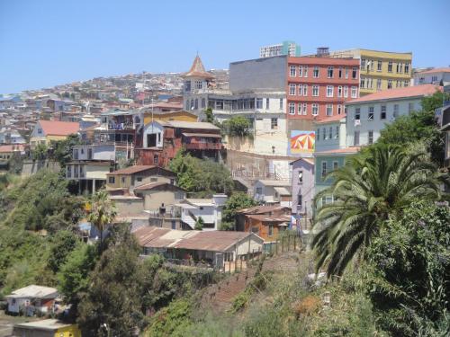 a group of buildings on a hill with a city at The Travelling Chile in Valparaíso