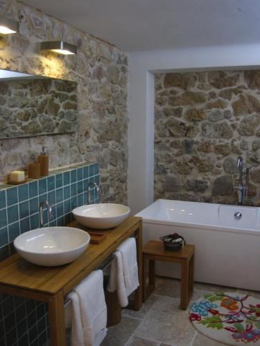 une salle de bain avec deux lavabos et une baignoire dans l'établissement Le Mas Nomade, à Callian