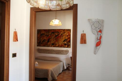 a doorway into a room with a bed and a painting at Antica Dimora del Portico in Borgiallo