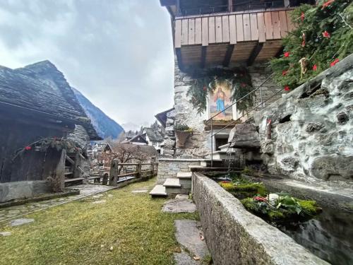 a stone building with stairs next to a mountain at Chalet Case delle lobbie in Ceppo Morelli