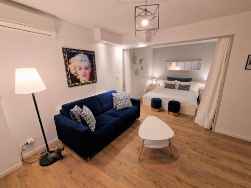 - un salon avec un canapé bleu et un lit dans l'établissement Magnifique vue mer - Piscine -Tennis, à Nice