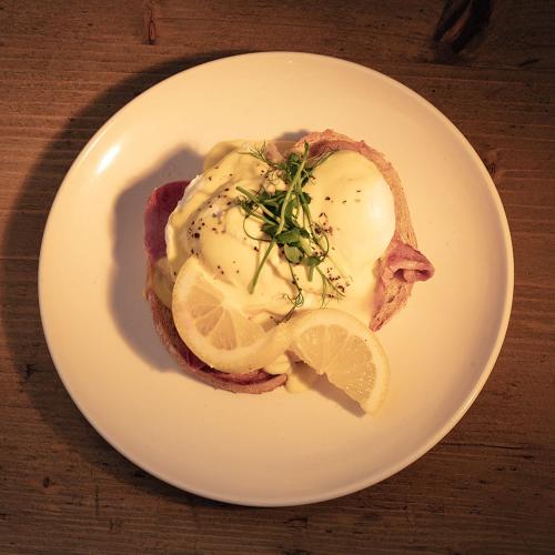 a white plate with a piece of meat with lemon slices at B&B Glamping Bell Tents at The Ring Pub in Gwredog