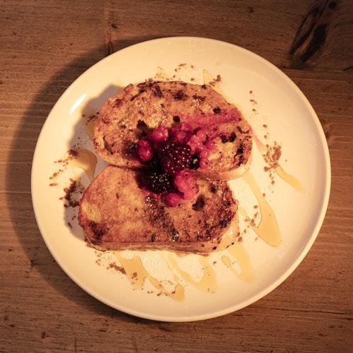 a white plate with a dessert with a blackberry on it at B&B Glamping Bell Tents at The Ring Pub in Gwredog
