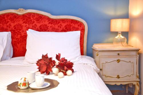 a bed with a red headboard and a tray with flowers on it at Lighthouse apartment in Corfu Town