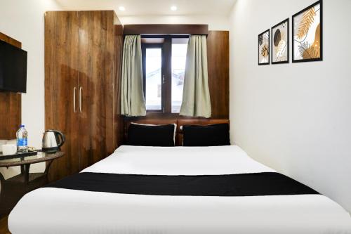 a bedroom with two beds and a window at Super Collection O Mall Road Nainital in Nainital