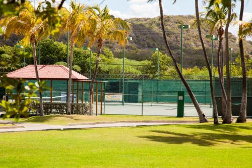 a tennis court with palm trees and a tennis courtermottermottermott at Copamarina Beach Resort & Spa in Guanica