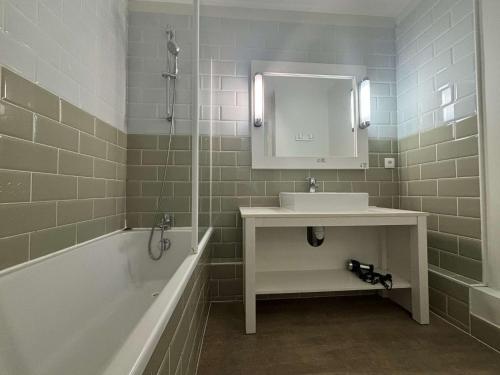 une salle de bain avec un lavabo, une baignoire et un miroir dans l'établissement Appt 2 pièces ILE DE RE - SAINT MARTIN DE RE - IDR400-054, à Saint-Martin-de-Ré