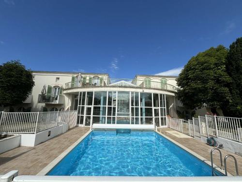 une grande maison avec une piscine devant dans l'établissement Appt 2 pièces ILE DE RE - SAINT MARTIN DE RE - IDR400-054, à Saint-Martin-de-Ré