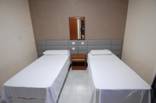 two beds in a small room with a mirror at El Hostal 36 in Seseña Nuevo