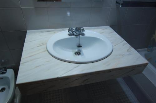 a white sink in a bathroom with a toilet at El Hostal 36 in Seseña Nuevo