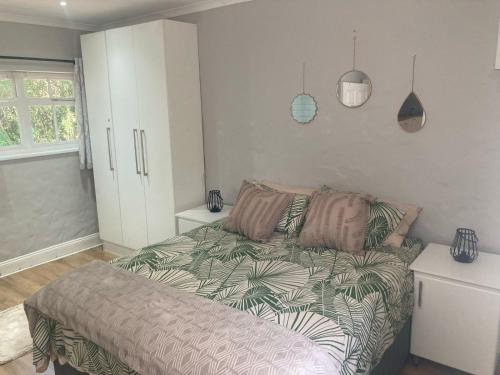 a bedroom with a bed and a white cabinet at The Nest at Au Petit Paradis in Gqeberha