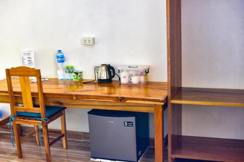 a wooden desk with a chair next to a table at Amanda Boutique in Nongkhiaw