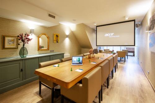 a conference room with a long table and chairs and a screen at Dikker & Thijs Hotel in Amsterdam