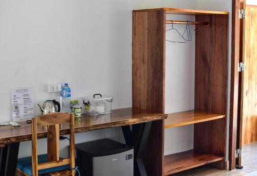 a room with a wooden desk and a refrigerator at Amanda Boutique in Nongkhiaw