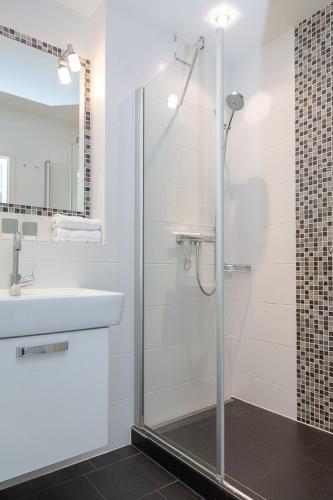 a bathroom with a glass shower and a sink at Big Wave _Vik1 _ 24_ in Westerland