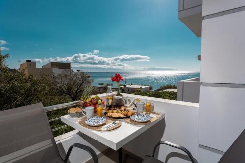 a breakfast table on a balcony with a view of the ocean at Avra 1 modern seaview home in Tsoútsouros