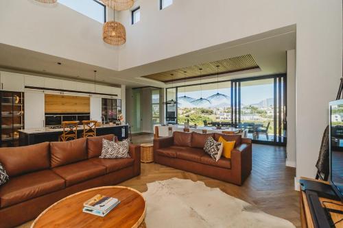 a living room with two brown couches and a table at Fairbourne's View, Kingswood Golf Estate George in George