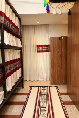 a room with a curtain and a door with a rug at Sands Inn Hostel - City Center in Riyadh