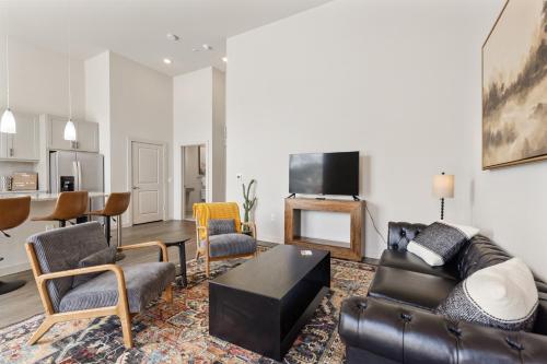 a living room with a couch and chairs and a tv at Luxury Loft Style Apartment in Austin